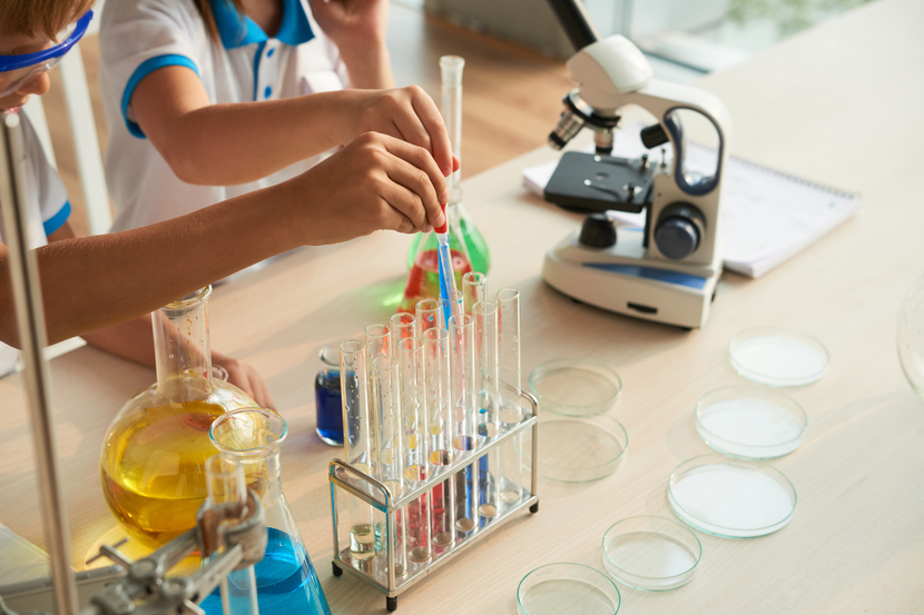 dois alunos realizando uma experiência química na escola