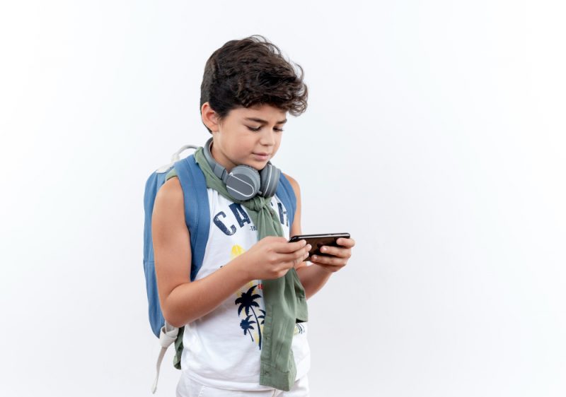 criança usando celular na sala de aula