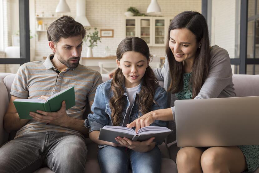 pai e mãe estudando junto com a filha