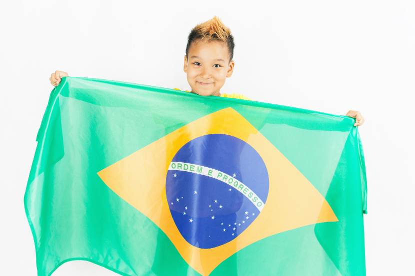 criança do Ensino Fundamental segurando bandeira do Brasil