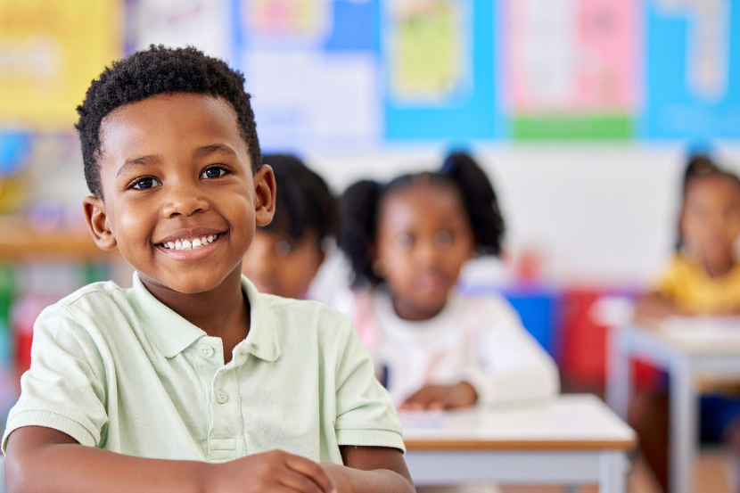 criança negra feliz representada na escola com educação antirracista