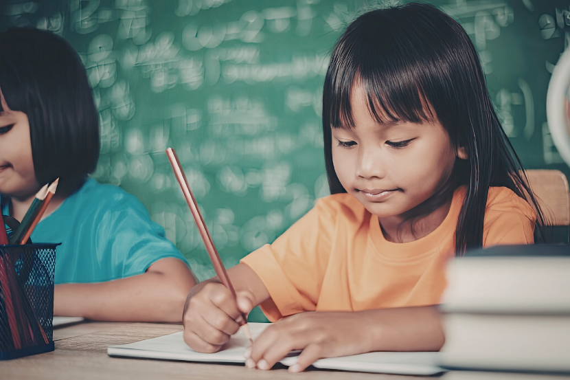 menina escrevendo no caderno representando as atividades dia mundial da língua portuguesa