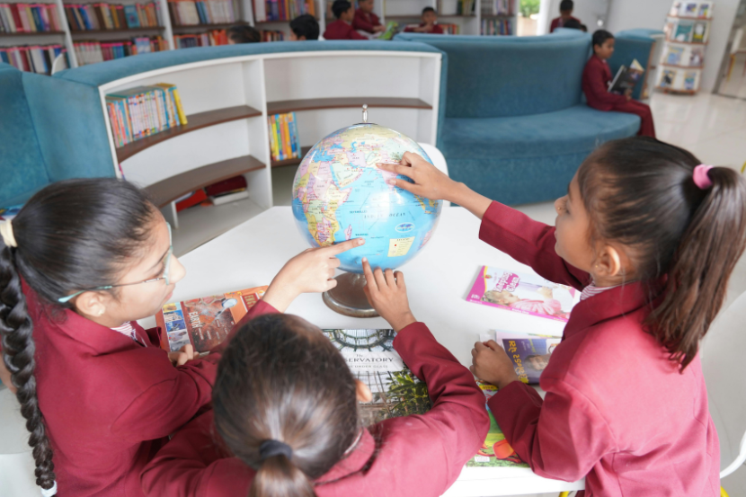 crianças explorando o globo terrestre em sala de aula